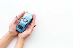 Car insurance concept, hands holding toy car