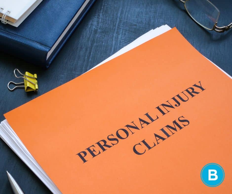 orange personal injury claim notebook sits on desk with stack of papers