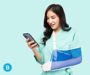 Asian woman with injured arm in white cast and blue sling using phone with other hand