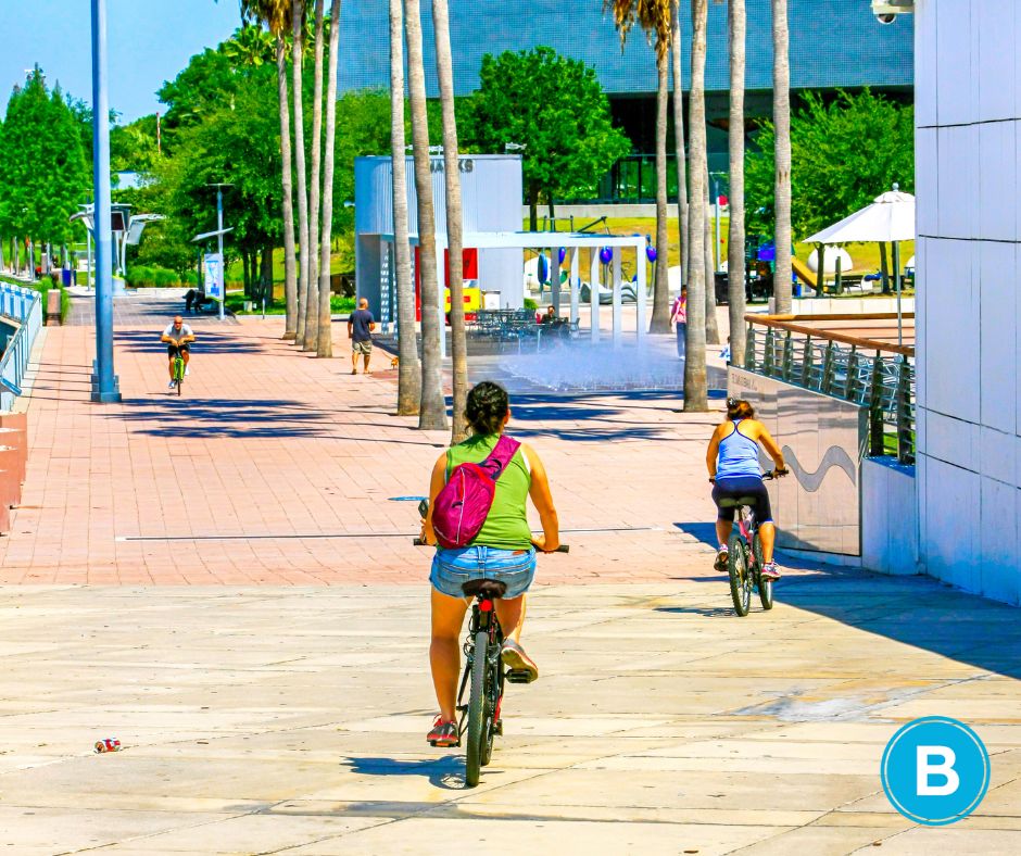bikers travel alongside Riverwalk in Tampa on a sunny day