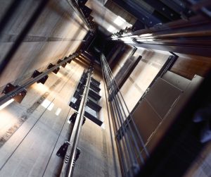 Looking up in empty, lit elevator shaft