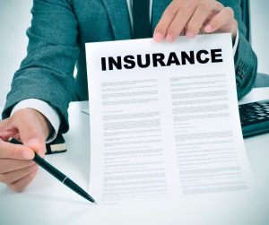 insurance document with agent pointing at line of text with pen
