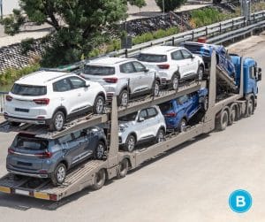 loaded car hauler driving down highway photographed from air