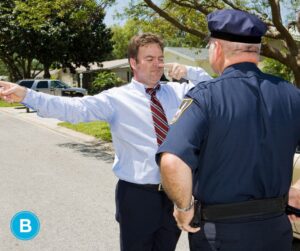 Officer is performing a field sobriety test on a middle-aged man in professional attire.
