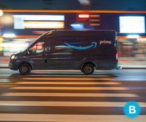 An Amazon delivery van driving through downtown area at night