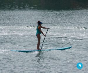 A paddleboarder on a Florida lake with the sun sparkling on the water.